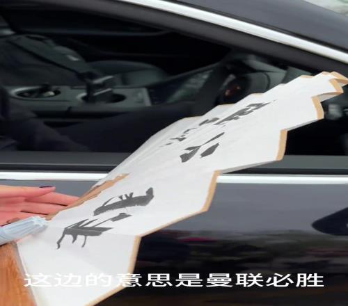 中国球迷送给阿莫林一把写着他名字的扇子，背面写着“曼联必胜”