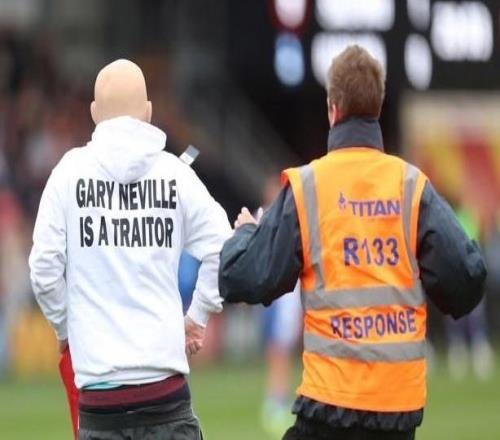 两男子穿着印有“加里内维尔是叛徒”的衣服，冲入英乙赛场